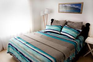 バリートにあるKedros@Ballitoのベッドルーム1室(青とグレーの枕が備わるベッド1台付)