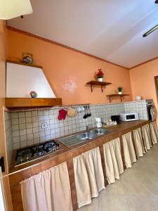 Il comprend une cuisine équipée d'un évier et d'une cuisinière. dans l'établissement Appartamento La Sicula, à Realmonte