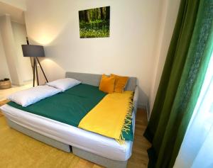 a bed in a room with a green and yellow blanket at Riga A new designed cosy family apartment in Riga