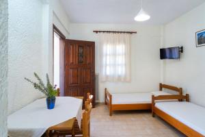 a room with two beds and a table and chairs at Kritikos Apartments in Pyrgadikia +22 photos