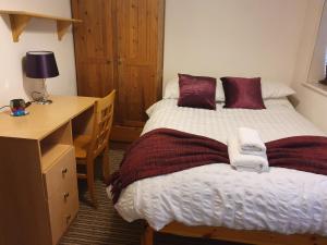 南安普敦的住宿－Chaps Guesthouse Southampton，一间卧室配有两张床、一张桌子和一张床