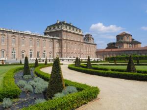 a large building with a garden in front of it at Guest House MICINI in Druento