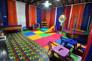 a colorful room with a play area with a slide at Hotel Porto dos Milagres in Aparecida