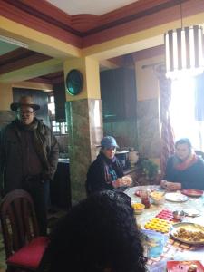 a group of people sitting around a table with food at Anugrah Homestay in Darjeeling