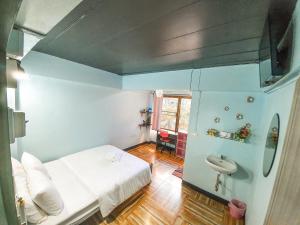 Bangkok Canale Home at Khaosarn في بانكوك: غرفة صغيرة بها سرير ومغسلة