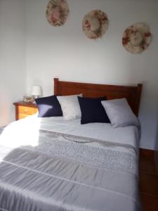 a bed in a bedroom with two plates on the wall at Casas da Nazare in Ponte de Lima