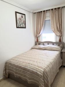 a bedroom with a bed and a window at Apartment Manuel Galián 52 in Torrevieja