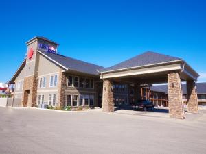 a large building with a car parked in front of it at BCMInns - Lac La Biche in Lac La Biche