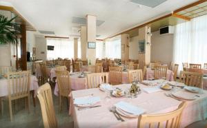 a dining room with tables and chairs with pink table cloth at Hotel Chic in Cattolica