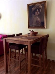 una mesa de madera con sillas y un retrato de una mujer en Vistamar Vueltas en Valle Gran Rey