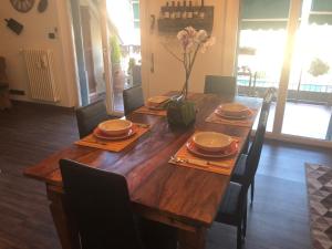 una mesa de madera con sillas y un jarrón de flores. en ATTIC HOUSE - IL TUO ATTICO A RAPALLO, en Rapallo
