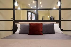 a bedroom with a bed with two pillows and a mirror at Suite Cagliari -99- in Cagliari