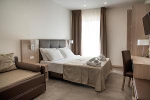Hotel Solemare - Frontemare - 3 Stelle Superior في ليدو دي يسولو: غرفه فندقيه بسرير واريكه