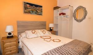 ein Schlafzimmer mit einem Bett mit zwei Gläsern darauf in der Unterkunft Casa con jardín a 5' de Aranda de Duero in Castrillo de la Vega