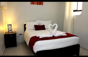 Un dormitorio con una cama con dos cisnes blancos. en Hostal Universal Huaraz, en Huaraz