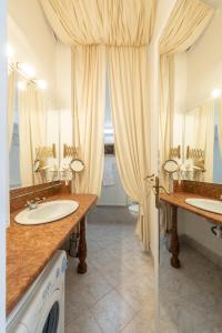 ein Badezimmer mit zwei Waschbecken und zwei Spiegeln in der Unterkunft Vintage Elegance MostCentralApt !Váci street! in Budapest