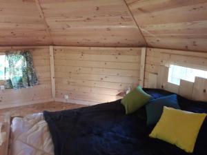 a room with a bed in a log cabin at CABANE DANS LES ARBRES in Ruaudin