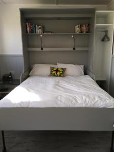 a white bed with a pillow on top of it at Ade's River Cabin in Lettermacaward