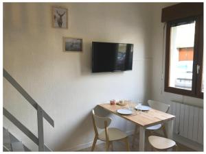 une salle à manger avec une table et une télévision murale dans l'établissement Nature & Scandinave, à Reims