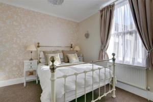a bedroom with a white bed and a window at Pannett View - in the heart of Whitby in Whitby
