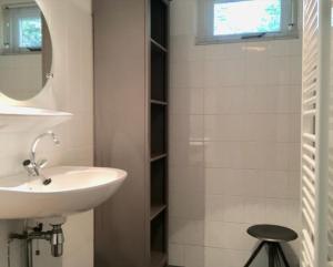 a bathroom with a sink and a mirror and a stool at Natuurhuisje Even Niets in Zelhem