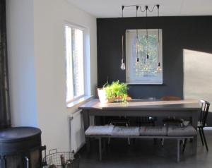 a kitchen with a counter with a table and benches at Natuurhuisje Even Niets in Zelhem