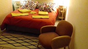 een slaapkamer met een bed met een stoel bij Le vitrail CHAMBRE Équipée sans service repas in Yvetot Bocage