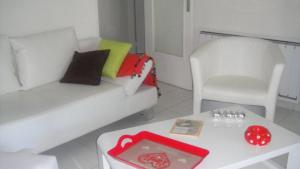 ein Wohnzimmer mit einer weißen Couch und einem Tisch in der Unterkunft T2 FRONT DE MER SUR LA PLAGE (ACCES PRIVE DIRECT PLAGE) VUE MER ET MONTAGNE in Argelès-sur-Mer