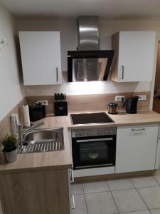 a kitchen with a sink and a stove top oven at Ferienwohnung "Vier Pfoten" in Korbach in Korbach
