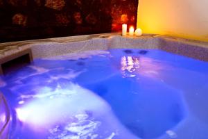 uma grande banheira azul com duas velas em ROUGA Mountain Boutique Suites & Spa em Palaios Agios Athanasios