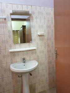 a bathroom with a sink and a mirror on the wall at IMMEUBLE KCF in Bamako