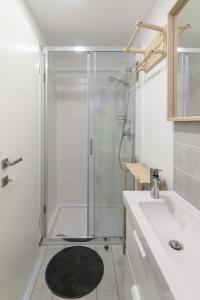 baño blanco con ducha y lavamanos en Garden living, en Bled