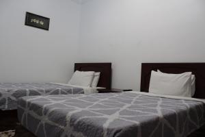 2 Betten nebeneinander in einem Zimmer in der Unterkunft Aist House in Buxoro