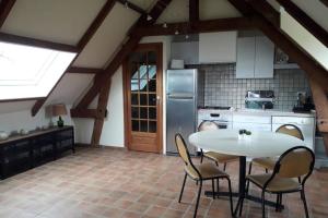 a kitchen with a table and chairs in a room at LES ENFANTS DU MOULIN in Saint-Léger-sur-Bresle