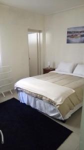 1 dormitorio con 1 cama blanca grande y ventana en Hostal Los Castaños, en Viña del Mar