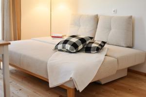 łóżko z dwoma czarno-białymi poduszkami w obiekcie Ferienwohnung am Sattelhof w mieście Türnitz