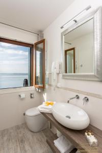 a bathroom with a sink and a toilet and a mirror at Locanda Stravedo in Pellestrina