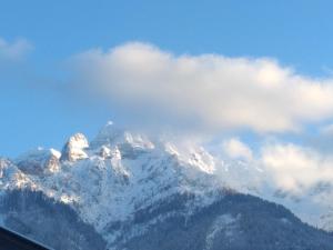 uma montanha coberta de neve e nuvens no céu em Ferienwohnung Zechner em Waidring