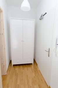 armadio bianco in camera con pavimento in legno di FeWo 2 Markranstädt a Markranstädt