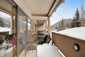eine Terrasse mit Stühlen und einem Grill im Schnee in der Unterkunft Ski Run Condominiums #108 in Keystone