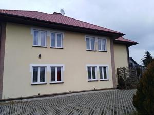 Casa blanca con ventanas blancas en una entrada de ladrillo en Pokoje Gościnne Strumykowa en Lublin