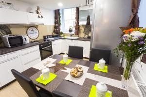 een keuken met een tafel en stoelen en een eetkamer bij Sweet getaway loft - new, central & parking in Ljubljana