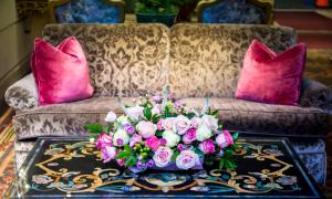 a table with a bouquet of flowers on a couch at Olyver Hotel in Los Angeles