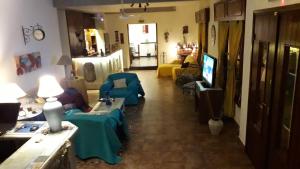 a living room with couches and a flat screen tv at Posada de la Villa in Villa Gesell