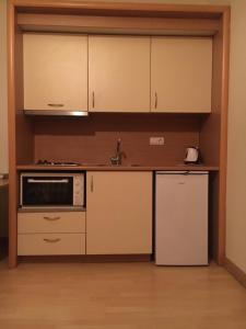 una cocina con armarios blancos y fregadero en PHILOXENIA PENSION en Ermioni