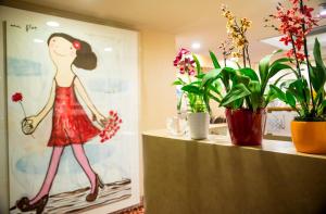 a room with a painting of a woman holding a flower at Olyver Hotel in Los Angeles