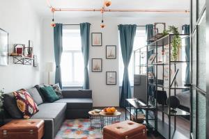 Design Apartment with King Size Bed - Six Minutes to Opera في فيينا: غرفة معيشة مع أريكة رمادية وستائر زرقاء