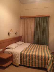 a hotel room with a bed and a window at PHILOXENIA PENSION in Ermioni