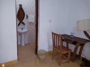 a bathroom with a table and a chair and a sink at Villa Mina beachhouse in Jambiani