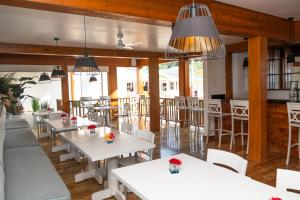 un restaurante con mesas blancas y sillas blancas en La Placita Inn, en West Bay